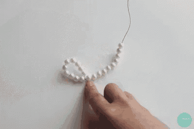 a person is holding a string of pearls in their hands .