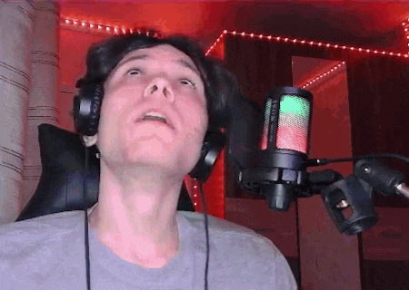 a man wearing headphones and a microphone with a green light on it