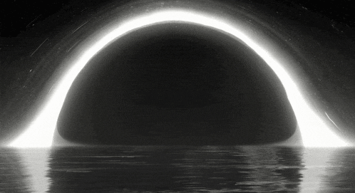 a black and white image of a black hole with a light coming out of it