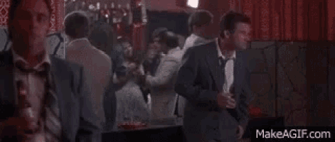 a man in a suit and tie is standing in a crowded room .