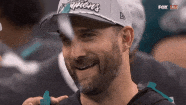 a man with a beard wearing a hat that says champions on it