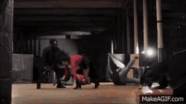 a group of people are dancing in a dark room with makeagif.com on the bottom of the screen