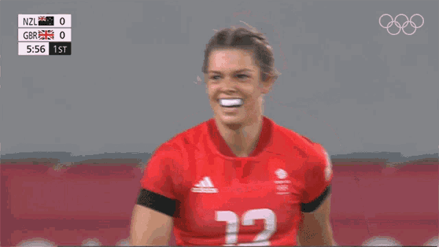 a female athlete wearing a red adidas jersey with the number 12 on it