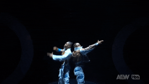two men are standing next to each other in a dark room with aew hds written on the bottom right corner