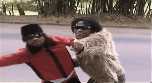 a man wearing a fur coat is pointing at another man