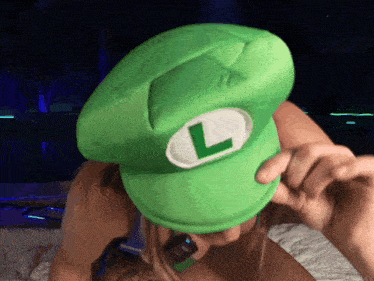 a woman wearing a green hat with a white l on it