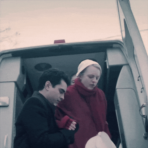 a man and a woman are standing next to each other in the back of a van