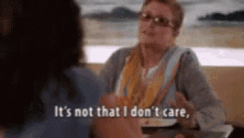 a woman is sitting at a table talking to another woman and saying it 's not that i don 't care