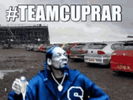 snoop dogg is holding a bottle of champagne in a parking lot