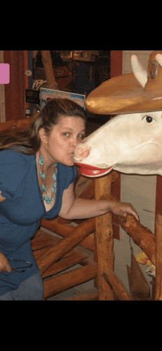 a woman kissing the nose of a statue of a cow