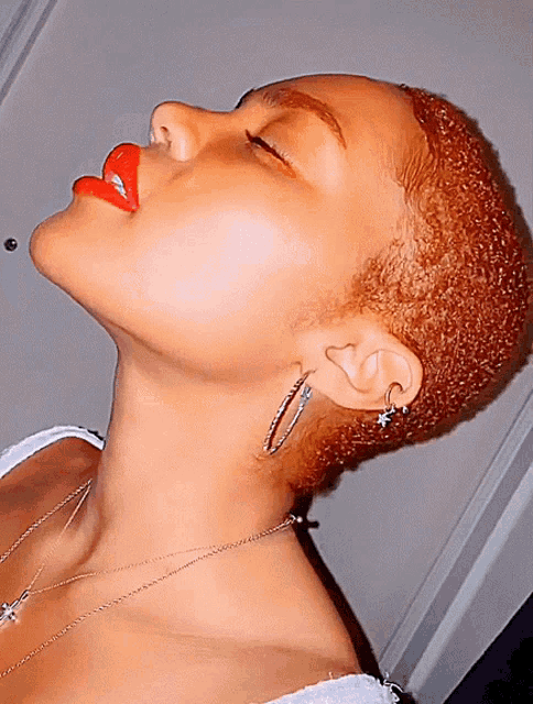 a close up of a woman 's face with red lipstick and earrings