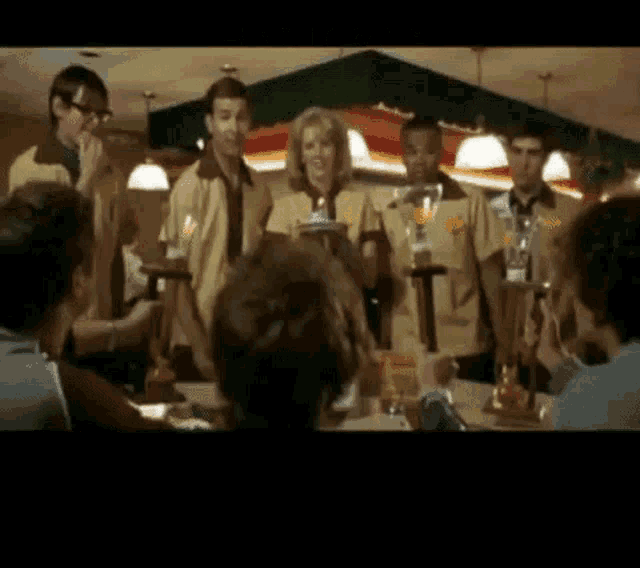 a group of people are standing around a table in a diner .