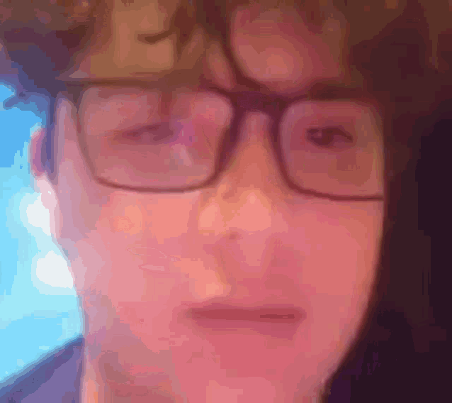 a close up of a person wearing glasses making a face .