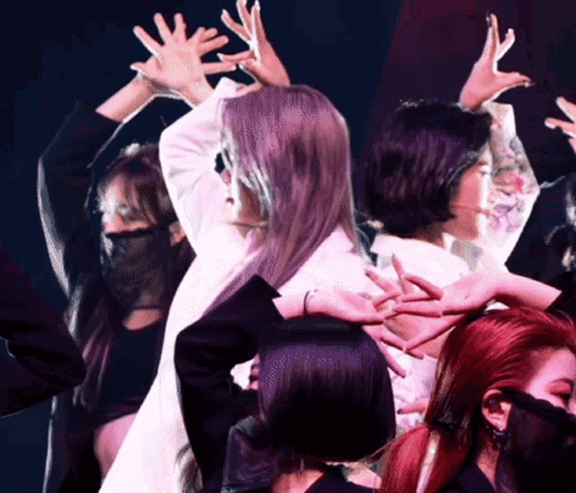 a group of women are dancing with their hands up in the air