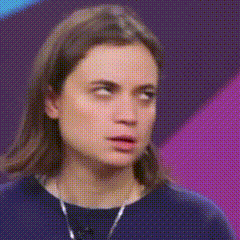 a woman with long hair is wearing a blue shirt and necklace