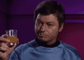 a man is holding a glass of orange juice .
