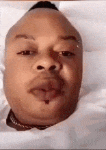 a close up of a man laying in a coffin with his tongue out .