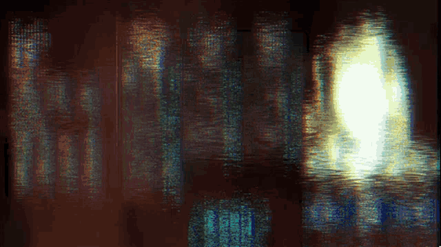 a blurred image of a dark room with a light shining through the window