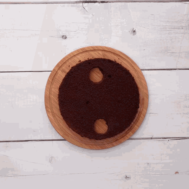 a wooden cutting board with a chocolate cake on it