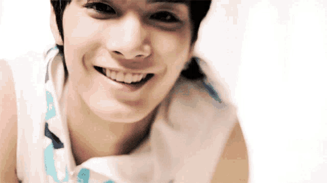 a close up of a young man 's face with a smile on his face