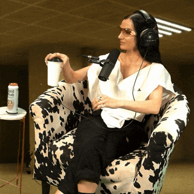 a woman wearing headphones is sitting in a cow print chair