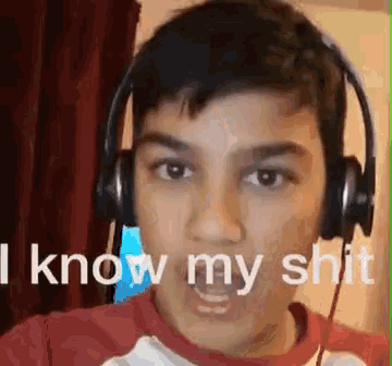 a young boy wearing headphones is making a funny face while saying `` i know my shit '' .