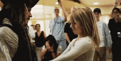 a man and a woman are dancing in a crowded room .