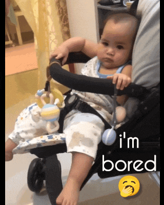 a baby is sitting in a stroller with the words " i 'm bored " next to it
