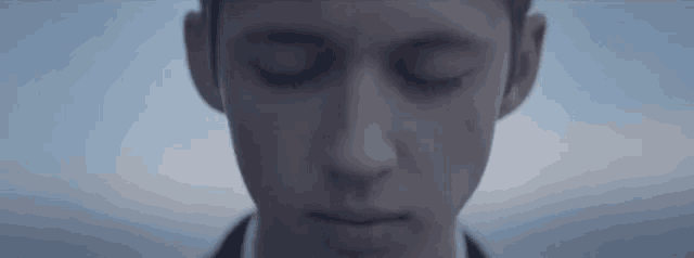 a close up of a man 's face with his eyes closed