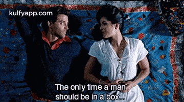 a man and a woman are laying on a bed and the man says the only time a man should be in a box ..