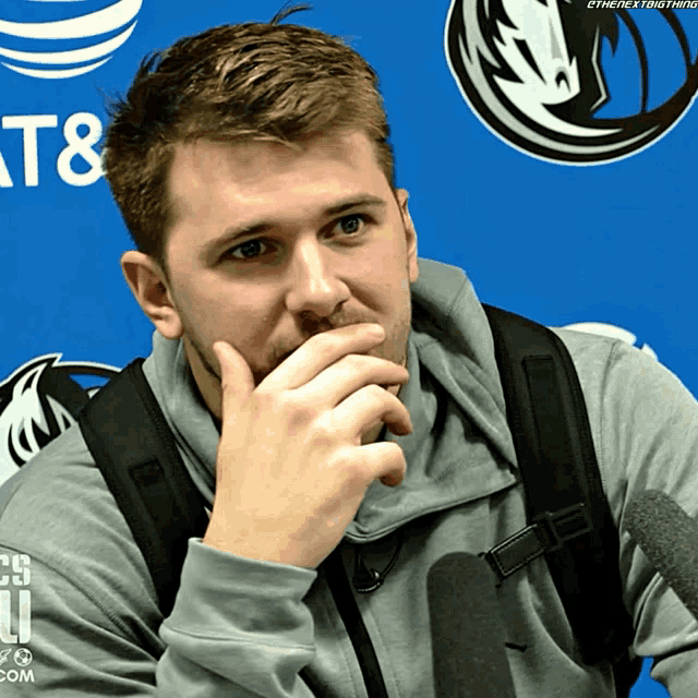 a man sitting in front of a sign that says at & t