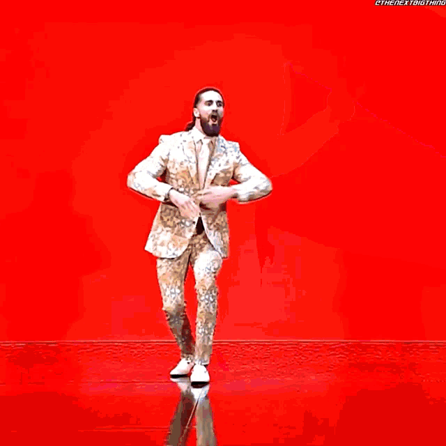 a man in a suit is dancing in front of a colorful background with the hashtag #thenextbig thing