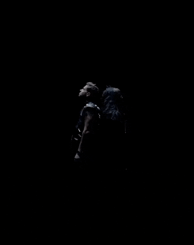 a man and a woman are standing next to each other in the dark