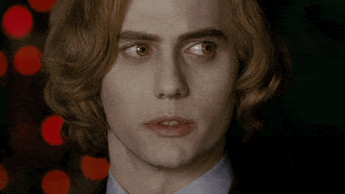 a close up of a man 's face with long hair