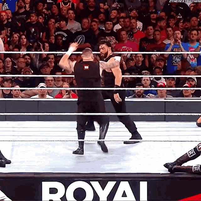 two wrestlers are in a ring with a sign that says royal
