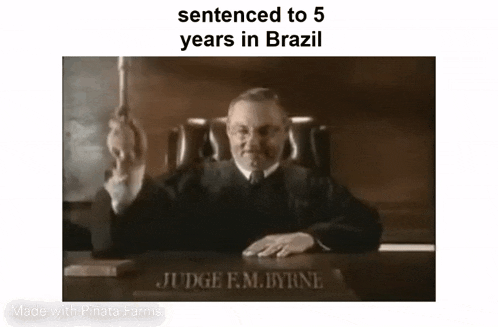 a judge is sitting at a desk in a courtroom and holding a gavel .