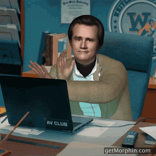 a man is sitting at a desk with a laptop that says av club