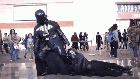 two people dressed as darth vader and kylo ren are posing for a picture .