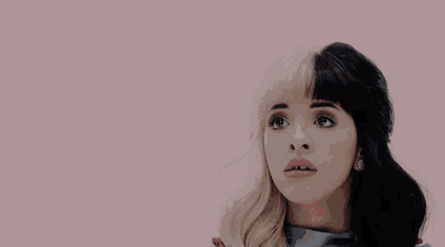 a woman with half blonde and half black hair is making a funny face