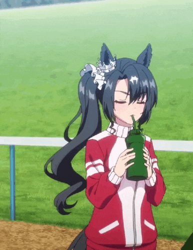 a girl in a red and white jacket is drinking from a green bottle