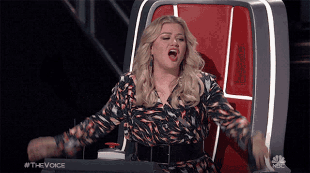 a woman is sitting in a chair with her arms outstretched and the words #thevoice on the bottom