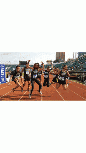 a group of people are standing on a track with a samsung sign in the background