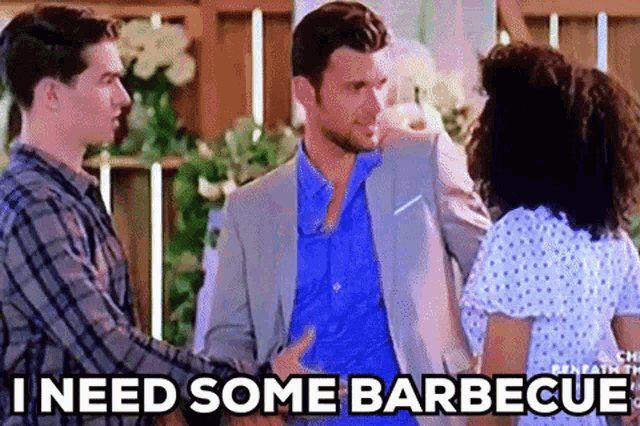a man in a suit is talking to a woman and another man .