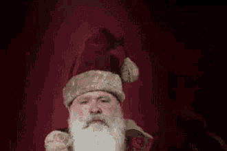 a close up of a man with a beard and a hat holding a candle .