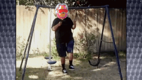a man is standing on a swing set with a balloon on his face