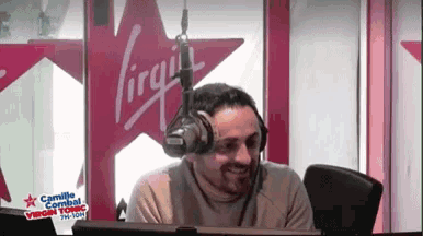 a man is wearing headphones in front of a virgin sign