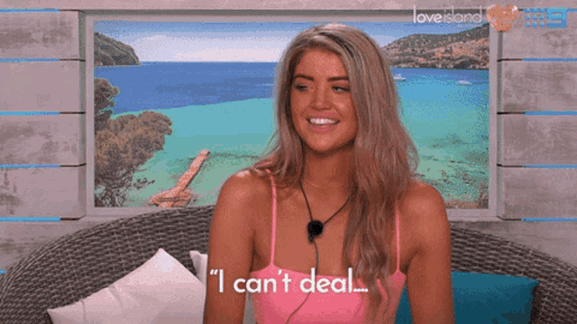 a woman sitting in front of a love island poster