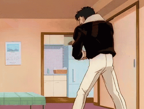 a man in a black jacket and white pants is standing in front of a door