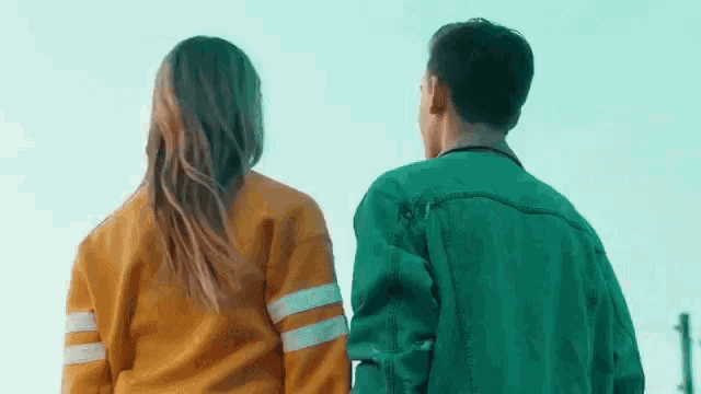 a man and a woman are holding hands and looking at each other .