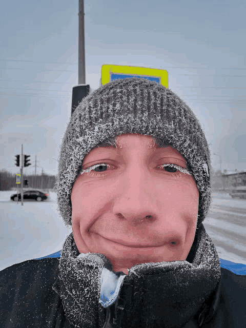 a man wearing a knitted hat is making a face